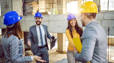 happy project managers shaking hands on job site