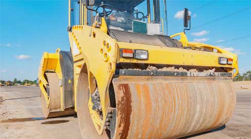 Heavy equipment that needs effective equipment management working on a road